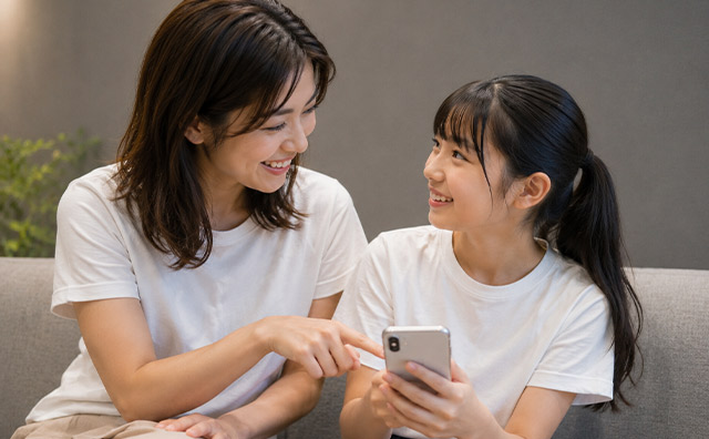 親子がスマホを見ている